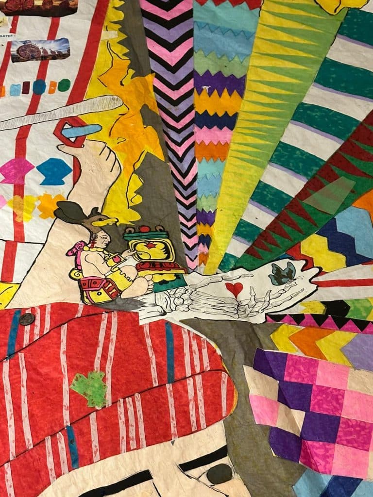 Colorido mural de arte urbano con elementos culturales diversos y patrones geométricos vibrantes.