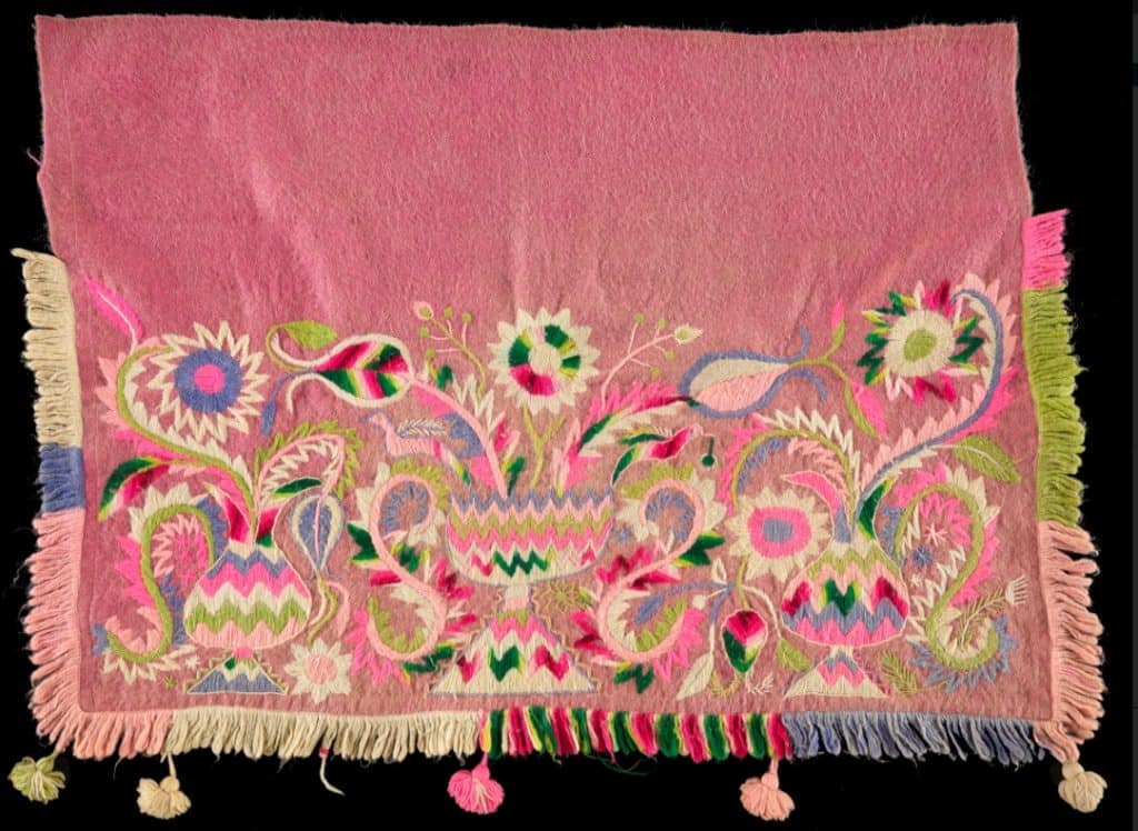 Colcha tejida con diseño floral y colores vibrantes, símbolo de tradición textil mexicana, ideal para decoración y coleccionismo en revista SoyMigrante.com REVISTA. – SoyMigrante.com REVISTA