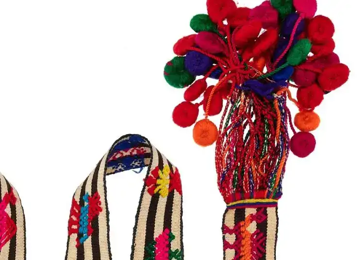 Colores vibrantes de artesanía indígena con telar tradicional y adornos de pompones para celebrar la cultura migrante en Revista SoyMigrante.com. – SoyMigrante.com REVISTA