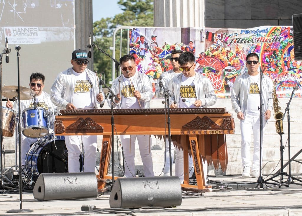 Festival Guatemala, banda musical en vivo, música tradicional en evento cultural, celebración folclórica, grupo musical en escenario, festival cultural en Guatemala, artistas en concierto, música en vivo, evento folklórico guatemalteco, cultural y artístico.