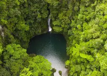 Lágrimas gigantes en la selva tropical con cascada y piscina de agua, vista aérea de exuberante vegetación verde en un paisaje natural impresionante.
