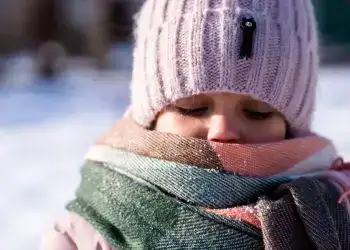 Pelea de la niña con bufanda y gorro de invierno, sobre fondo de nieve, en clima frío, transporte internacional, comunidad migrante, vida en el extranjero, historias de migrantes, revisa la revista SoyMigrante.com REVISTA.
