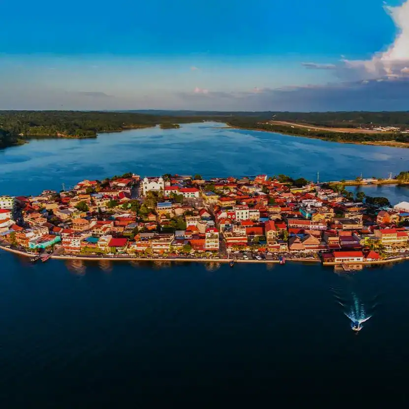 Puerto fluvial con casas tradicionales en un pueblo cercano a un río, reflejando cultura y vida local, ideal para temas de migración, historias de comunidad y turismo en México. – SoyMigrante.com REVISTA