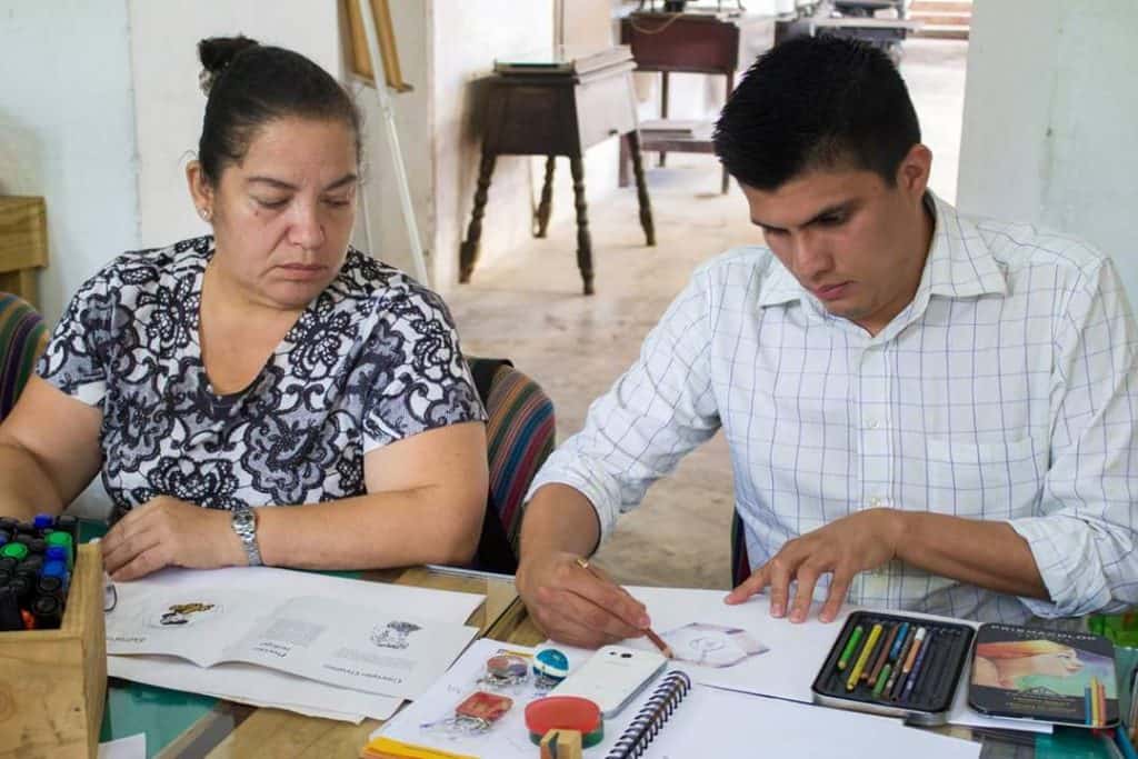 Estudiante dibujando en una clase de arte en un ambiente educativo, promoviendo la creatividad y el talento en el aprendizaje artístico.