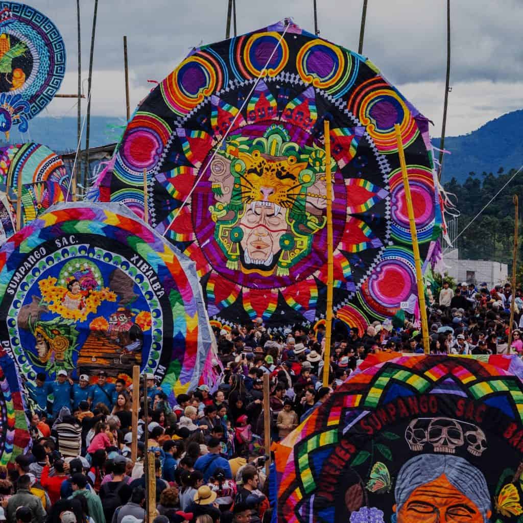 Vuelos de papalotes tradicionales en la celebración de Día de Muertos en México, con coloridos diseños y gran multitud participando en la festividad indígena. – SoyMigrante.com REVISTA