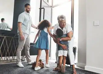 Familia migrante recibiendo a un ser querido en la oficina, emotivo reencuentro, cultura migrante, integración familiar, sentimientos de amor y alegría, comunidad de inmigrantes.