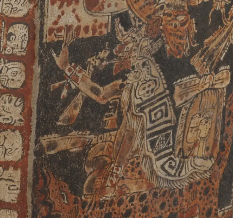 El personaje principal de la escena parece ser un gobernante, ataviado con máscara de jaguar. Está fumando sobre un trono cubierto con piel de jagua, un animal sagrado para los mayas. Detalle de foto del museo del Condado de los Angeles, utilizada bajo licencia Creative Commons para propósitos educativos y de difusión cultural. – SoyMigrante.com REVISTA El personaje principal de la escena parece ser un gobernante, ataviado con máscara de jaguar. Está fumando sobre un trono cubierto con piel de jagua, un animal sagrado para los mayas. Detalle de foto del museo del Condado de los Angeles, utilizada bajo licencia Creative Commons para propósitos educativos y de difusión cultural. – SoyMigrante.com REVISTA