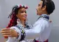 Diversidad cultural en celebración, figura de muñecos de pareja con trajes tradicionales, representación artística de migrantes en la Revista SoyMigrante, enfatizando la integración y cultura latinoamericana. – SoyMigrante.com REVISTA