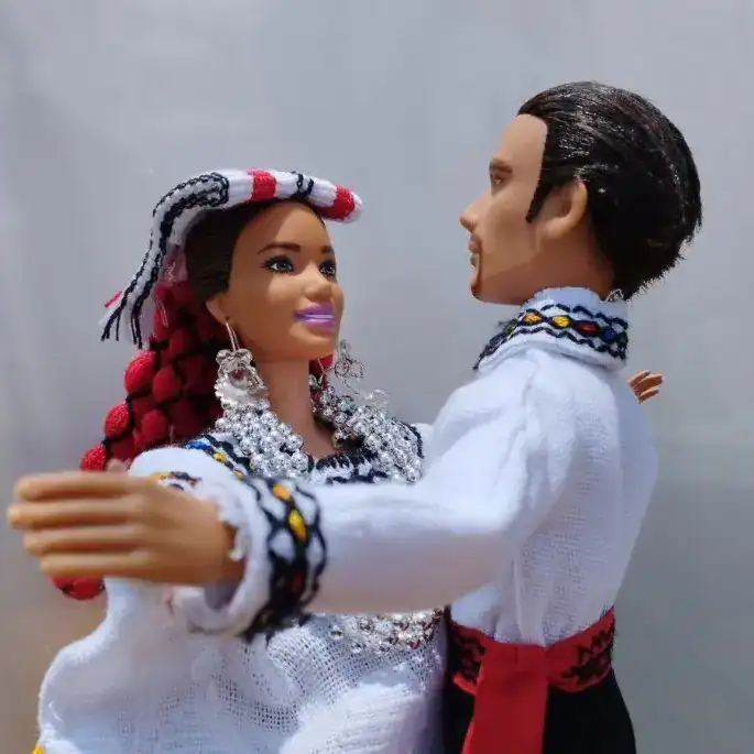 Diversidad cultural en celebración, figura de muñecos de pareja con trajes tradicionales, representación artística de migrantes en la Revista SoyMigrante, enfatizando la integración y cultura latinoamericana. – SoyMigrante.com REVISTA