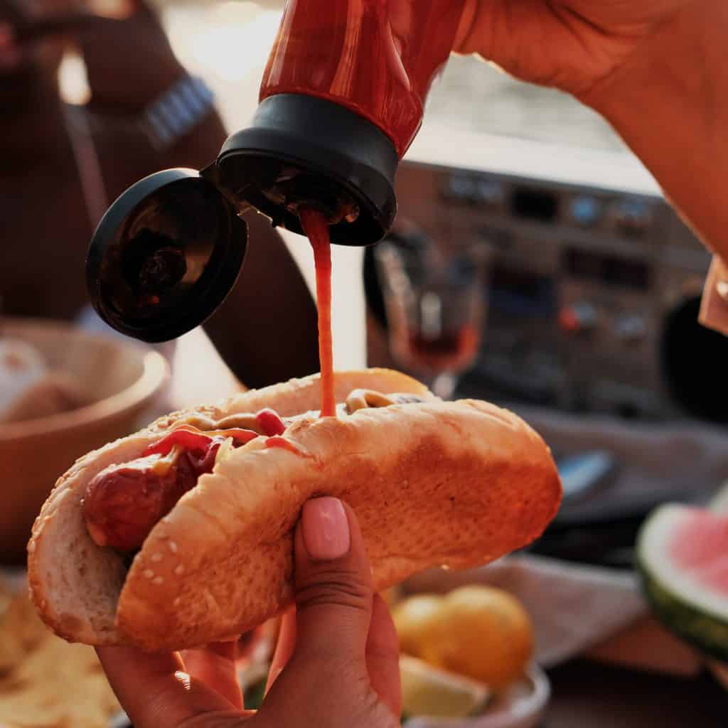 Aorita: Salsa ketchu y otra salsa en un hot dog, un típico alimento callejero en festivales latinoamericanos.