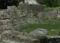 Restos arqueológicos de una antigua ciudad en las ruinas de un sitio prehispánico en México, muestra vestigios históricos y culturales en un entorno natural verde y selvático.