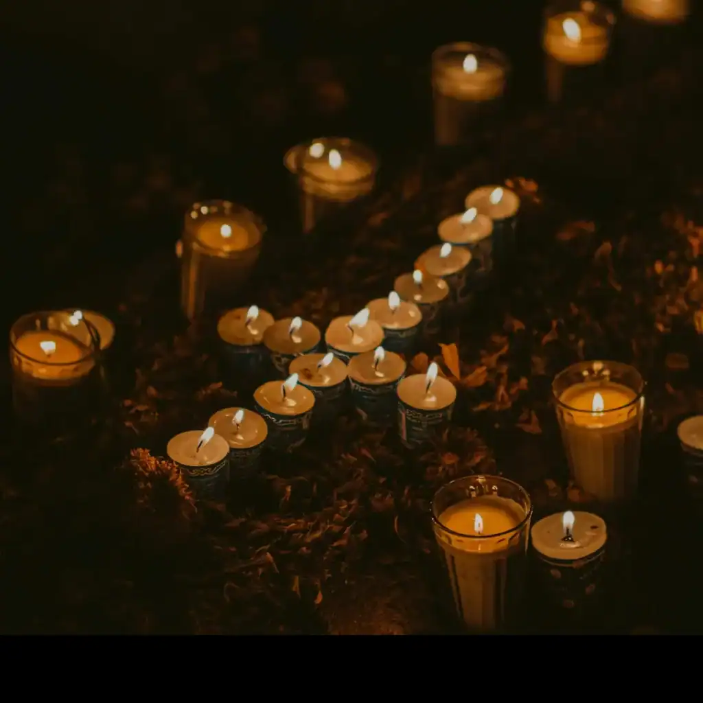 Velas encendidas en honor a migrantes, símbolo de memoria y esperanza en la comunidad migrante en homenaje en SoyMigrante.com REVISTA.