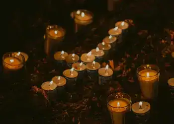 Velas encendidas en honor a migrantes, símbolo de memoria y esperanza en la comunidad migrante en homenaje en SoyMigrante.com REVISTA.