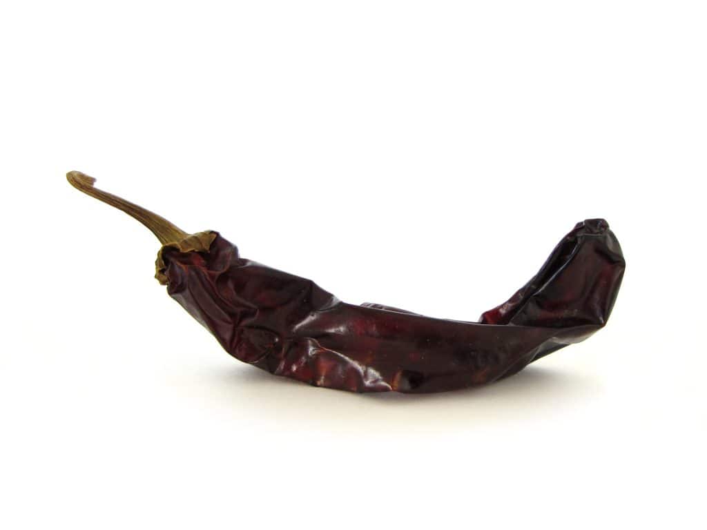 Chile seco, símbolo de la gastronomía y cultura mexicana, ideal para preparar salsas y adobos en la cocina tradicional mexicana, con un sabor intenso y picante.