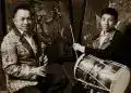 Profesionales músicos latinoamericanos en un evento cultural, tocando instrumentos tradicionales y participando en actividades artísticas en un entorno vibrante y colorido.