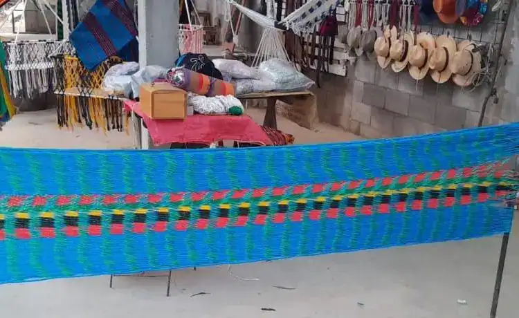 Entretejido artesanal colorido en mercado tradicional mexicano, exhibiendo tejidos y accesorios culturales, representando la riqueza de la cultura indígena en comunidades rurales.