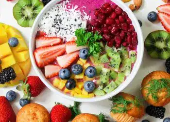 Refresco de acai con frutas tropicales, berries, kiwis y mango, en un bol colorido que representa salud, bienestar y estilo de vida saludable para la comunidad migrante en tendencia.