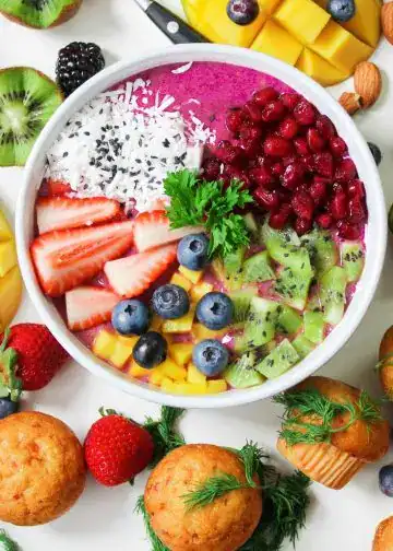 Las frutas que fortalecen tus defensas contra las gripes 1 – SoyMigrante.com REVISTA Refresco de acai con frutas tropicales, berries, kiwis y mango, en un bol colorido que representa salud, bienestar y estilo de vida saludable para la comunidad migrante en tendencia. – SoyMigrante.com REVISTA