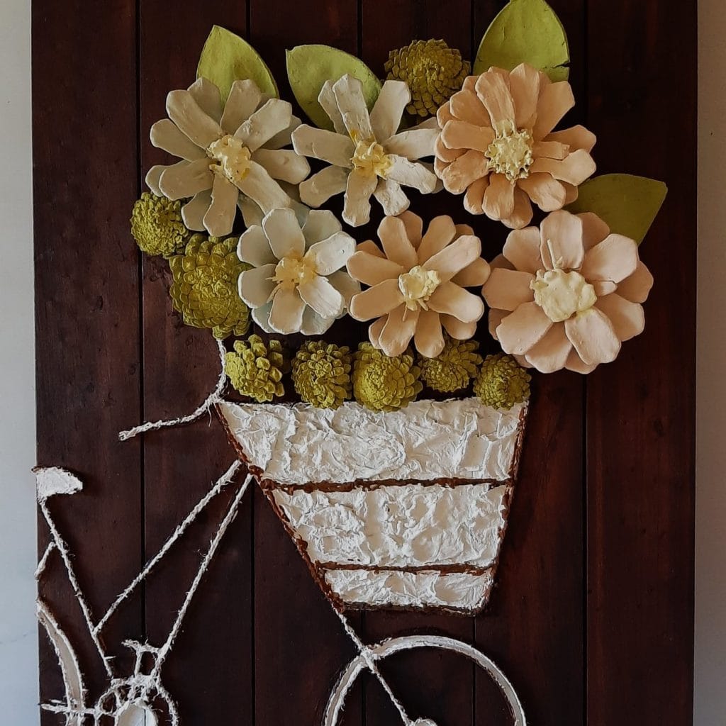 Mural de flores decorativas en tonos pastel, conrecipiente de cesto rústico y decorativo, en fondo de madera oscura, arte floral para decoración de interiores, estilo natural y elegante, para espacios acogedores y cálidos. – SoyMigrante.com REVISTA