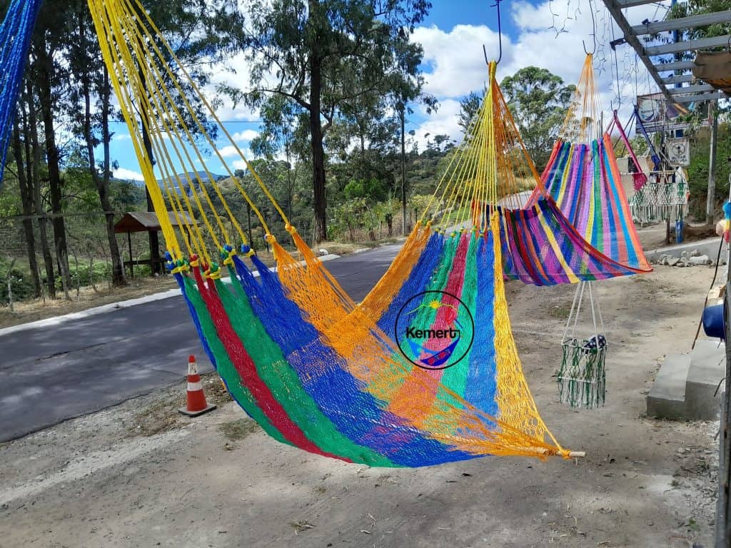 Columpios colgados de colores vibrantes en un entorno natural, ideales para relajarse y disfrutar del aire libre en un espacio comunitario o turístico. – SoyMigrante.com REVISTA