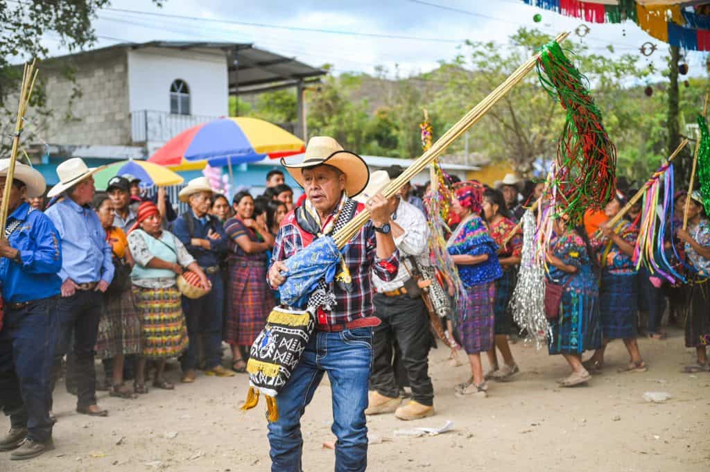 Fiesta tradicional en comunidad indígena con baile y vestimentas coloridas, demostrando cultura y raíces en un evento festivo en México. – SoyMigrante.com REVISTA