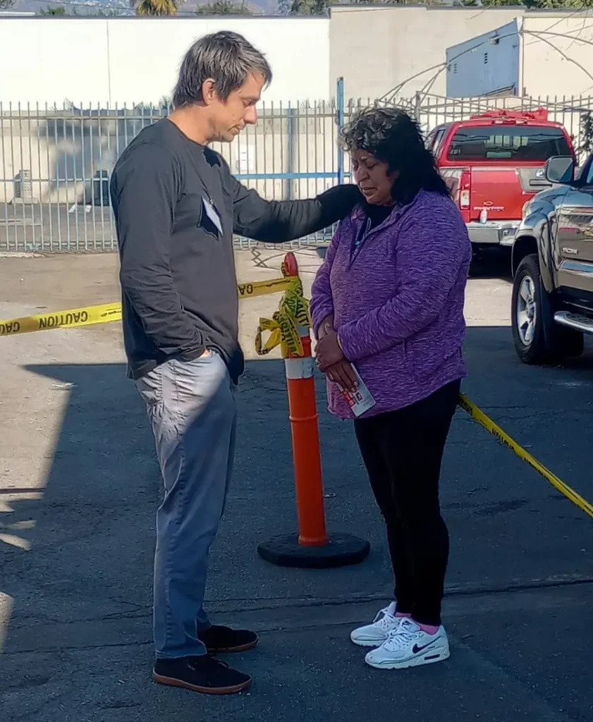 Voluntario Edgar Reyes ora por una pobladora afectada por los incendios de Los Angeles. ¡No toda la ayuda es material, también se necesita apoyo espiritual y emocional!(Foto Red Migrante Guatemalteca) – SoyMigrante.com REVISTA Voluntario Edgar Reyes ora por una pobladora afectada por los incendios de Los Angeles. ¡No toda la ayuda es material, también se necesita apoyo espiritual y emocional!(Foto Red Migrante Guatemalteca) – SoyMigrante.com REVISTA