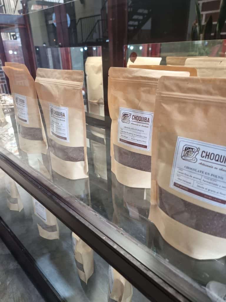 Dulces artesanales de chocolate en polvo en bolsas de papel en una vitrina. – SoyMigrante.com REVISTA