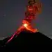 Erupción volcánica activa en noche estrellada, explosión de lava y ceniza emergiendo del volcán. Imagen impresionante de un volcán en erupción en un entorno natural y nocturno.