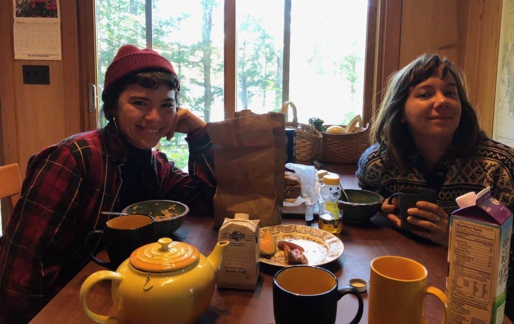 Personas disfrutando un desayuno casero en una acogedora cocina con vista a la naturaleza, ideal para contenidos sobre vida migrante y cultura en México.