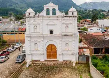 Nueva iglesia colonial en un pueblo de montaña, destacada por su arquitectura blanca y detalles tradicionales en un entorno rural. Perfecta para turismo cultural y patrimonio histórico.