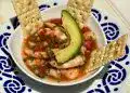 Deliciosa entrada de cóctel de camarones con aguacate y galletas saladas en platos tradicionales mexicanos, ideal para cultura y gastronomía mexicana en Revista SoyMigrante.com.