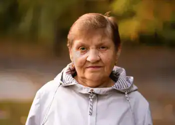 Cuidar la salud mental en la tercera edad1 – SoyMigrante.com REVISTA Anciana migrante sonriendo al aire libre, ejemplo de resistencia y fortaleza migratoria en la comunidad latina. – SoyMigrante.com REVISTA