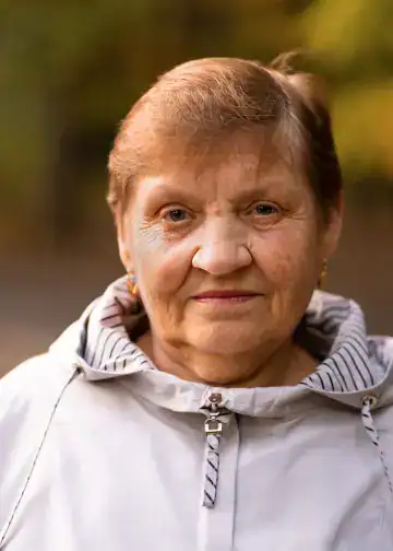 Anciana migrante sonriendo al aire libre, ejemplo de resistencia y fortaleza migratoria en la comunidad latina. – SoyMigrante.com REVISTA