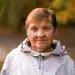 Anciana migrante sonriendo al aire libre, ejemplo de resistencia y fortaleza migratoria en la comunidad latina.