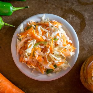 Fresca ensalada de col y zanahoria, plato saludable y nutritivo, ideal para dietas y comidas ligeras. Salmon rebanado, verduras frescas y ingredientes naturales para una alimentación balanceada. – SoyMigrante.com REVISTA