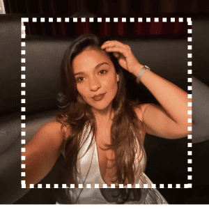 SoyMigrante, revista para migrantes y comunidad latinoamericana, mujer joven con cabello largo y oscuro, en entorno de cine o teatro, estilo elegante y confianza en sí misma.