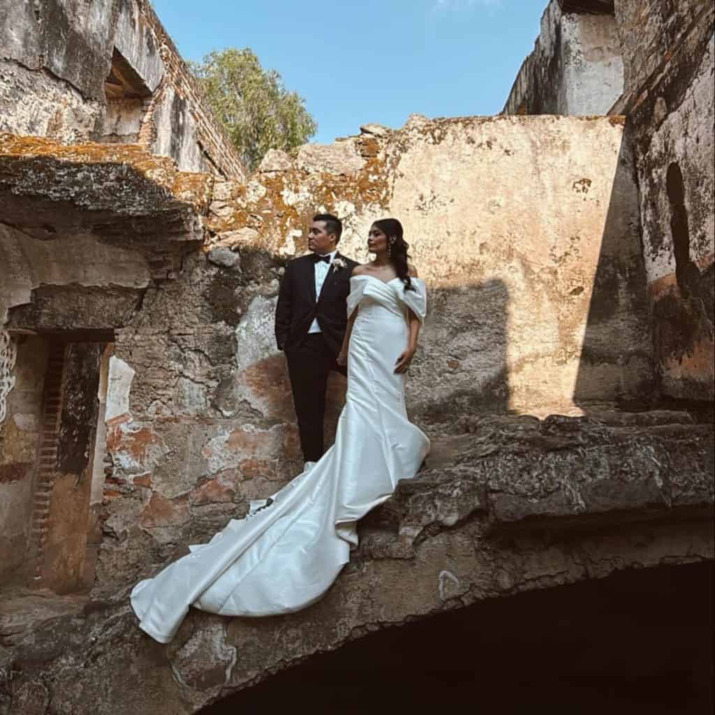 Vestido de novia y traje de novio en escenario histórico, fotografía de boda en lugar antiguo y romántico, celebración matrimonial en ruin structures, amor y compromiso en la ceremonia.