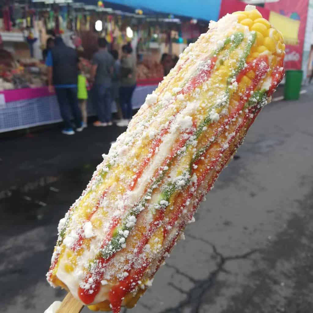 Paleta de hielo de hielo de frutas con polvo, en feria callejera mexicana, refrescante y deliciosa, ideal para verano, con sabor a mango, tamarindo y chile.