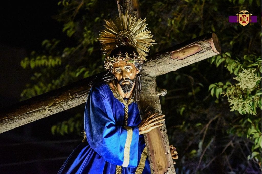 Misterio y cultura mexicana en la fotografía de una figura religiosa con vestimenta tradicional y atributos culturales, representando tradiciones en festividades religiosas y patrimonio cultural.