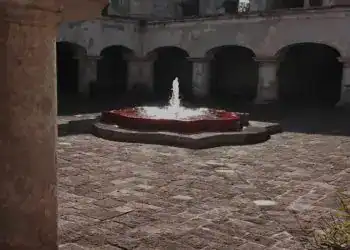 Fuente en el centro de la terraza con fuente de agua en un patio histórico. Edificio colonial con arcos y paredes de piedra, ambiente tranquilo y clásico en el interior de un edificio antiguo.