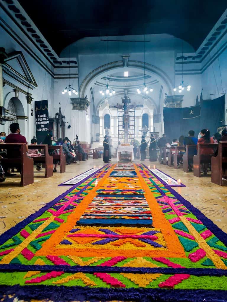 El amor de un pueblo a Dios llega hasta la puerta de su casa para pedir un mañana mejor. – SoyMigrante.com REVISTA Colorido tapete de alfombra nymx en una iglesia durante una ceremonia religiosa en el contexto de la revista SoyMigrante.com REVISTA. – SoyMigrante.com REVISTA