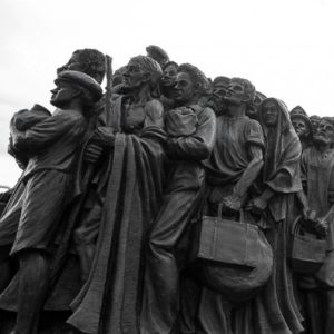 Una escultura de migrantes en movimiento, simbolizando la historia y la lucha de los migrantes en busca de mejores oportunidades y derechos. Ideal para reflejar temas de migración, derechos humanos y cultura en América Latina.