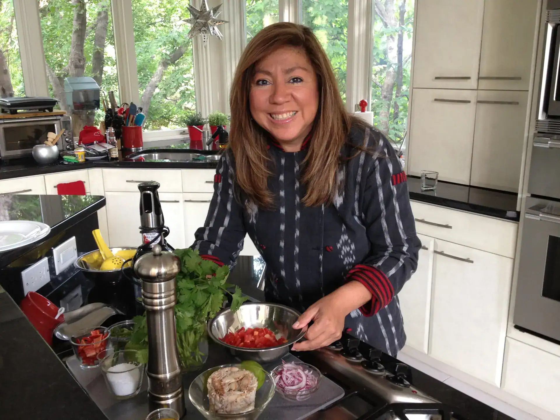 Cocinera en cocina luminosa preparando ensalada mexicana con ingredientes frescos, verduras y hierbas, en un entorno acogedor y natural, ideal para contenido de migrantes y recetas tradicionales. – SoyMigrante.com REVISTA