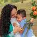 Amor y protección entre madre e hijo, celebración de la maternidad, vínculo familiar, felicidad, cariño, afecto, maternidad, inmigrantes, comunidad, bienestar familiar, flores, expresión de amor.