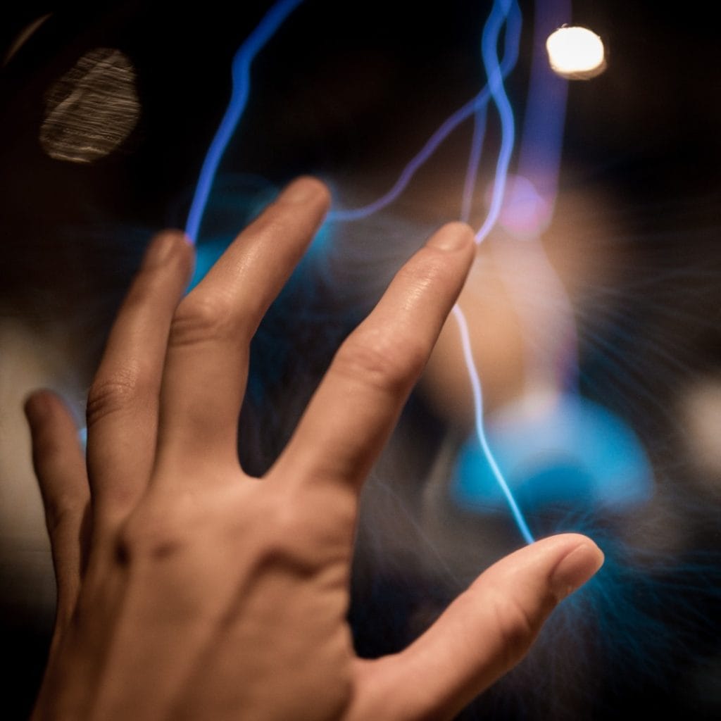 Corriente eléctrica y tecnología moderna, imagen de mano interactuando con electricidad en un entorno oscuro, tecnología e innovación en el contexto de la revista SoyMigrante.com REVISTA, enfoque en avances tecnológicos y migrantes digitales. – SoyMigrante.com REVISTA