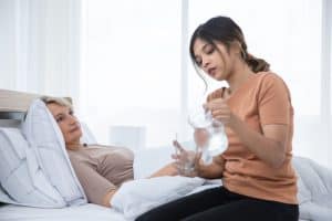 Paciente en cama recibiendo atención médica para fortalecer su salud y bienestar en el hospital. Profesionales de la salud brindan cuidados especializados y apoyo emocional.