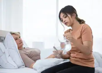 Paciente en cama recibiendo atención médica para fortalecer su salud y bienestar en el hospital. Profesionales de la salud brindan cuidados especializados y apoyo emocional. – SoyMigrante.com REVISTA