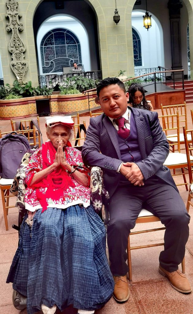 Juan Alejandro "Xixo" Rax y su abuela Ana Cho, fueron invitados a cambiar la Rosa de la Paz en el Palacio Nacional en 2024. Para ella fue un gran honor y alegría que la Danza de las Guacamayas fuera declarada Patrimonio Cultural de la Nación en 2023. (Foto cortesía Xixo Rax) – SoyMigrante.com REVISTA Juan Alejandro "Xixo" Rax y su abuela Ana Cho, fueron invitados a cambiar la Rosa de la Paz en el Palacio Nacional en 2024. Para ella fue un gran honor y alegría que la Danza de las Guacamayas fuera declarada Patrimonio Cultural de la Nación en 2023. (Foto cortesía Xixo Rax) – SoyMigrante.com REVISTA