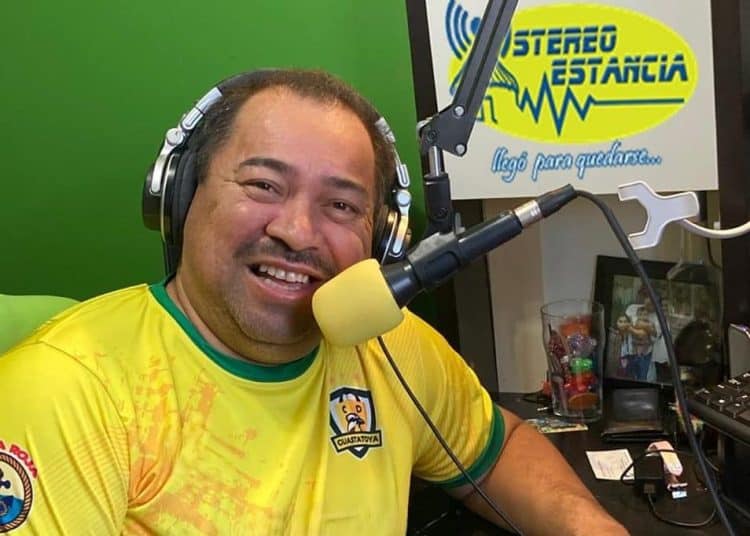 Radioaficionado con auriculares en estudio de grabación, promocionando SoyMigrante.com Revista sobre migración, cultura y comunidad en medio de entorno profesional de radio y comunicación.