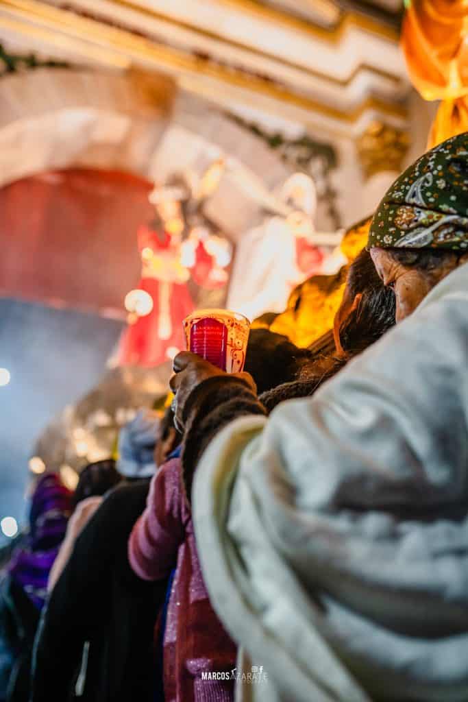 "Madre, he ahí a tu hijo", dice el sermón de las 7 palabras. – SoyMigrante.com REVISTA Hierro. Imagen de personas participando en una ceremonia religiosa tradicional en un espacio con decoración dorada y luces cálidas, resaltando la cultura mexicana y las tradiciones religiosas. – SoyMigrante.com REVISTA
